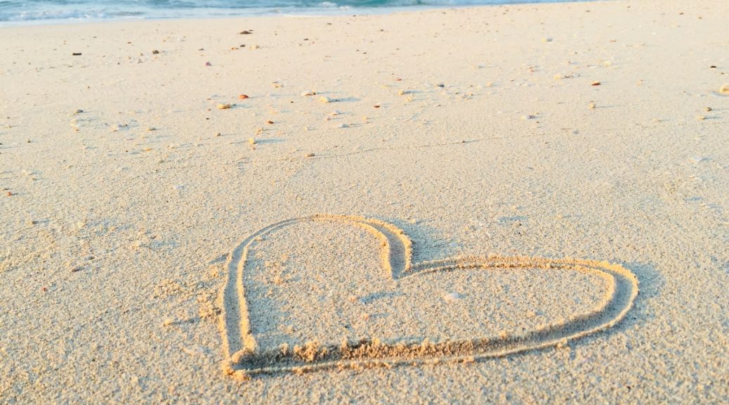 heart drawn on sand during daytime